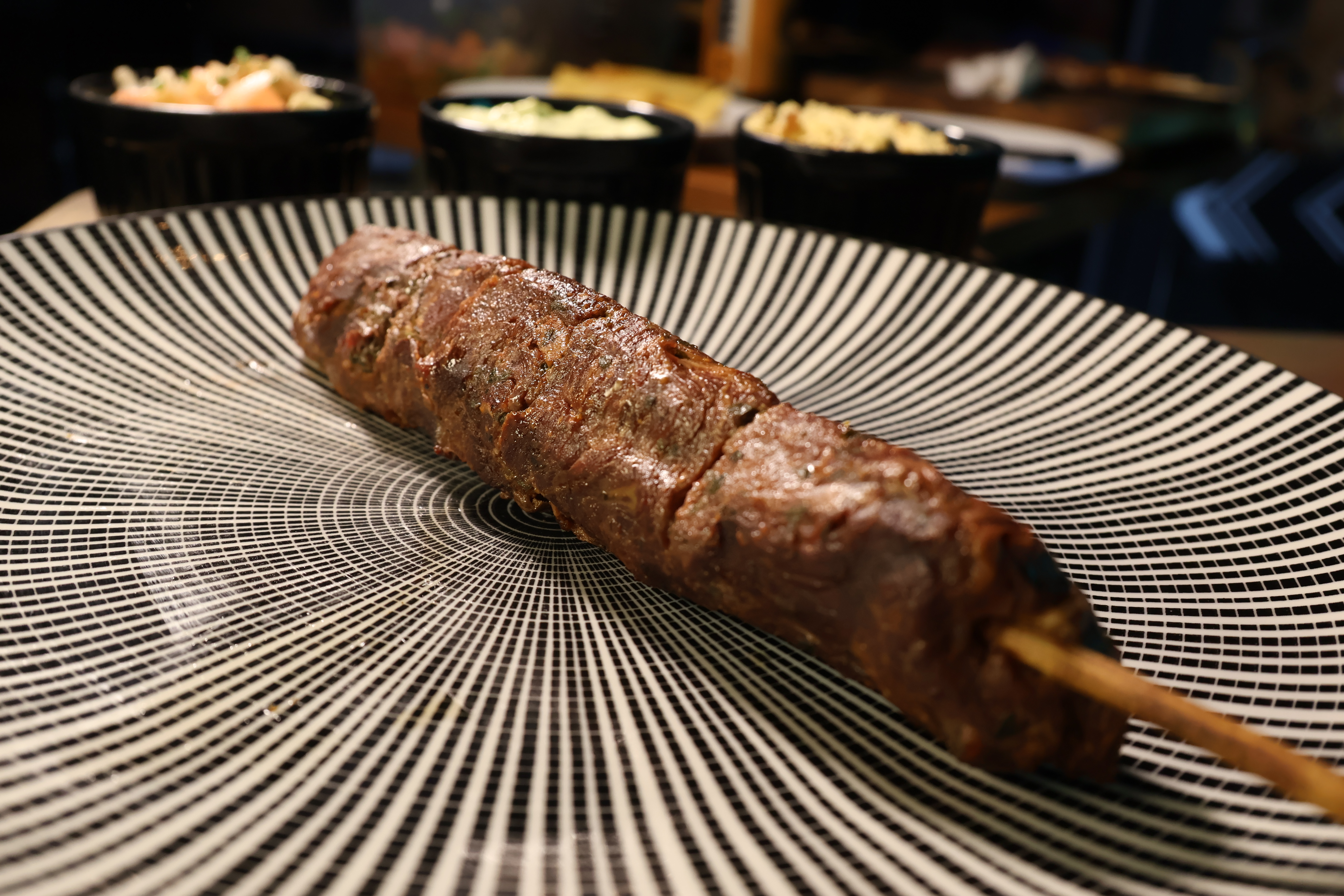 Espeto de carne assando na brasa do Di Propósito